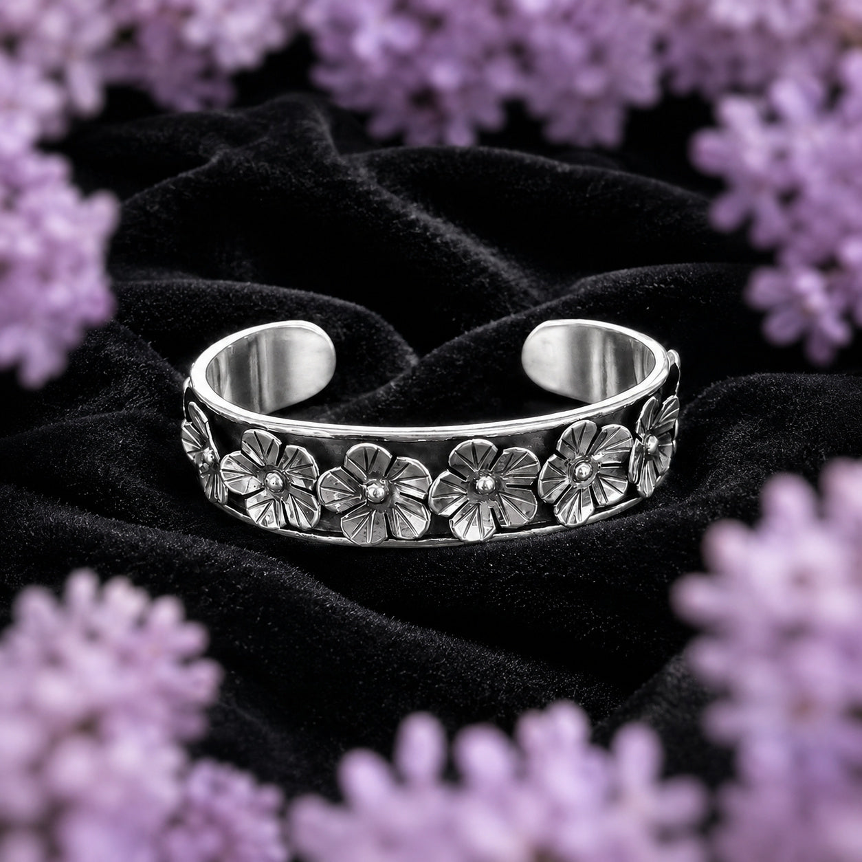 Brazalete de Flores de plata ley .925 de Joyería Colibrí sobre terciopelo negro, enmarcado por un halo de lavanda