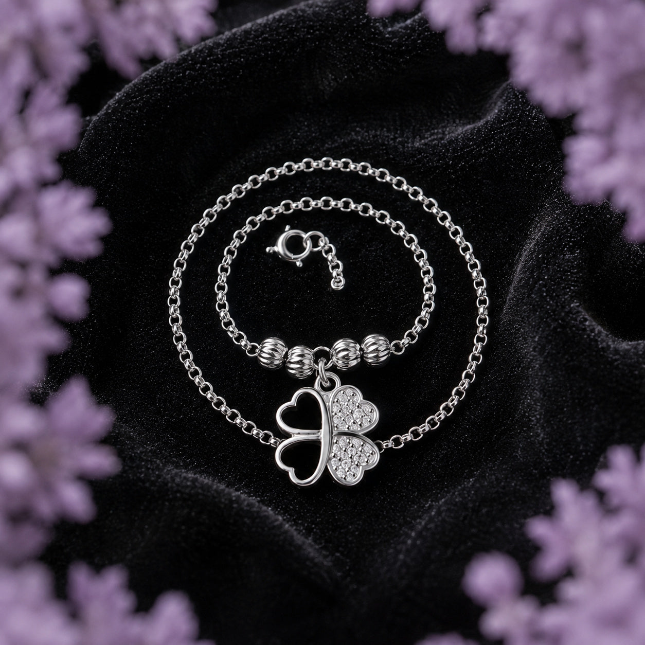 Gargantilla Trébol de Corazones de plata ley .925 de Joyería Colibrí sobre terciopelo negro, enmarcada por un halo de lavanda