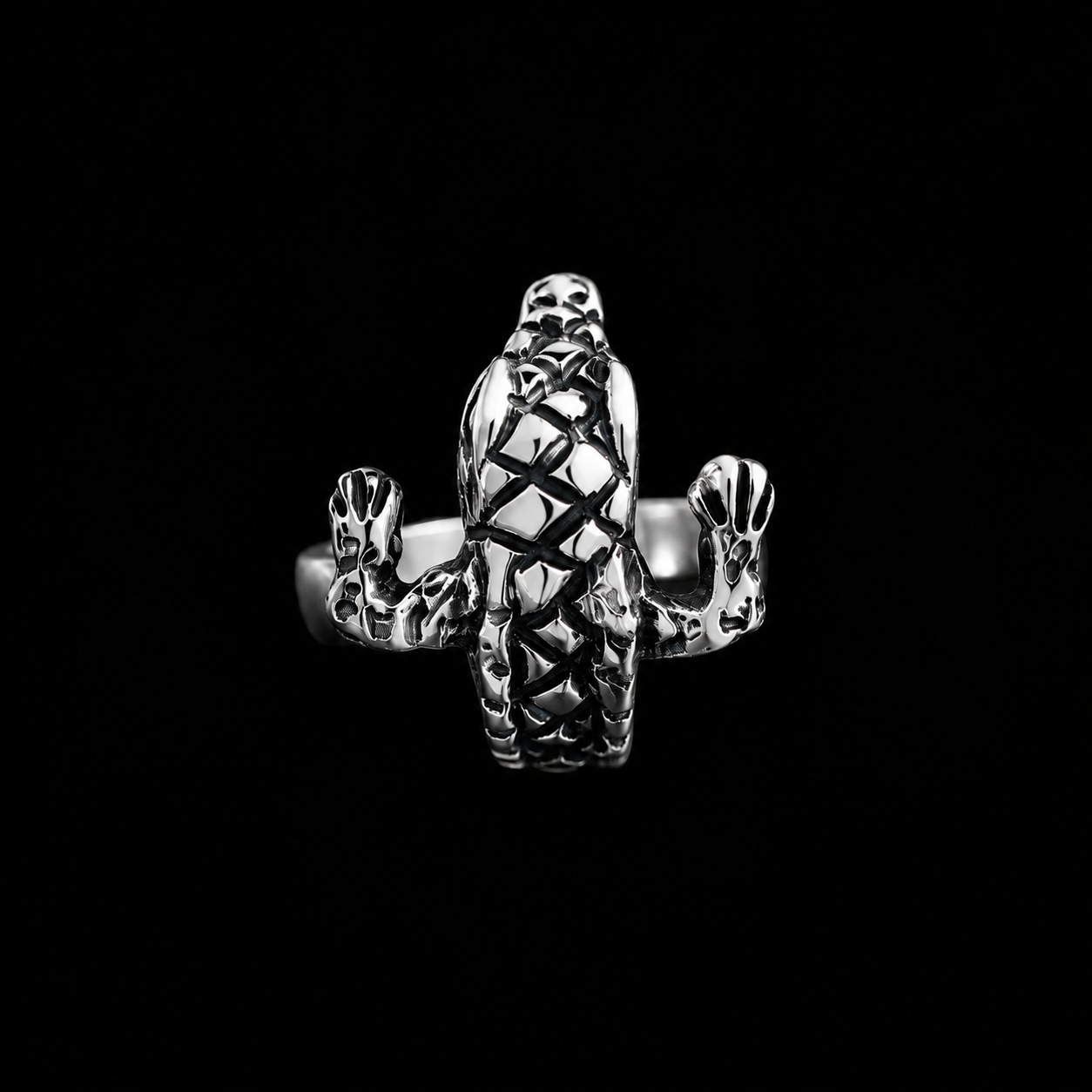Anillo Cocodrilo de plata ley .925 sobre fondo negro, con el cocodrilo de escamas oxidadas visto de frente