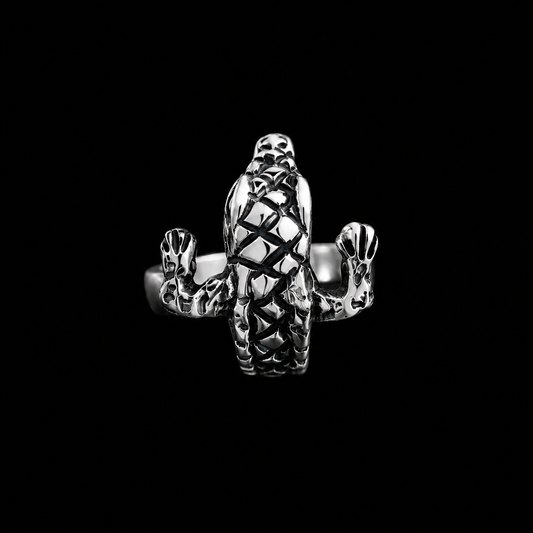 Anillo Cocodrilo de plata ley .925 sobre fondo negro, con el cocodrilo de escamas oxidadas visto de frente