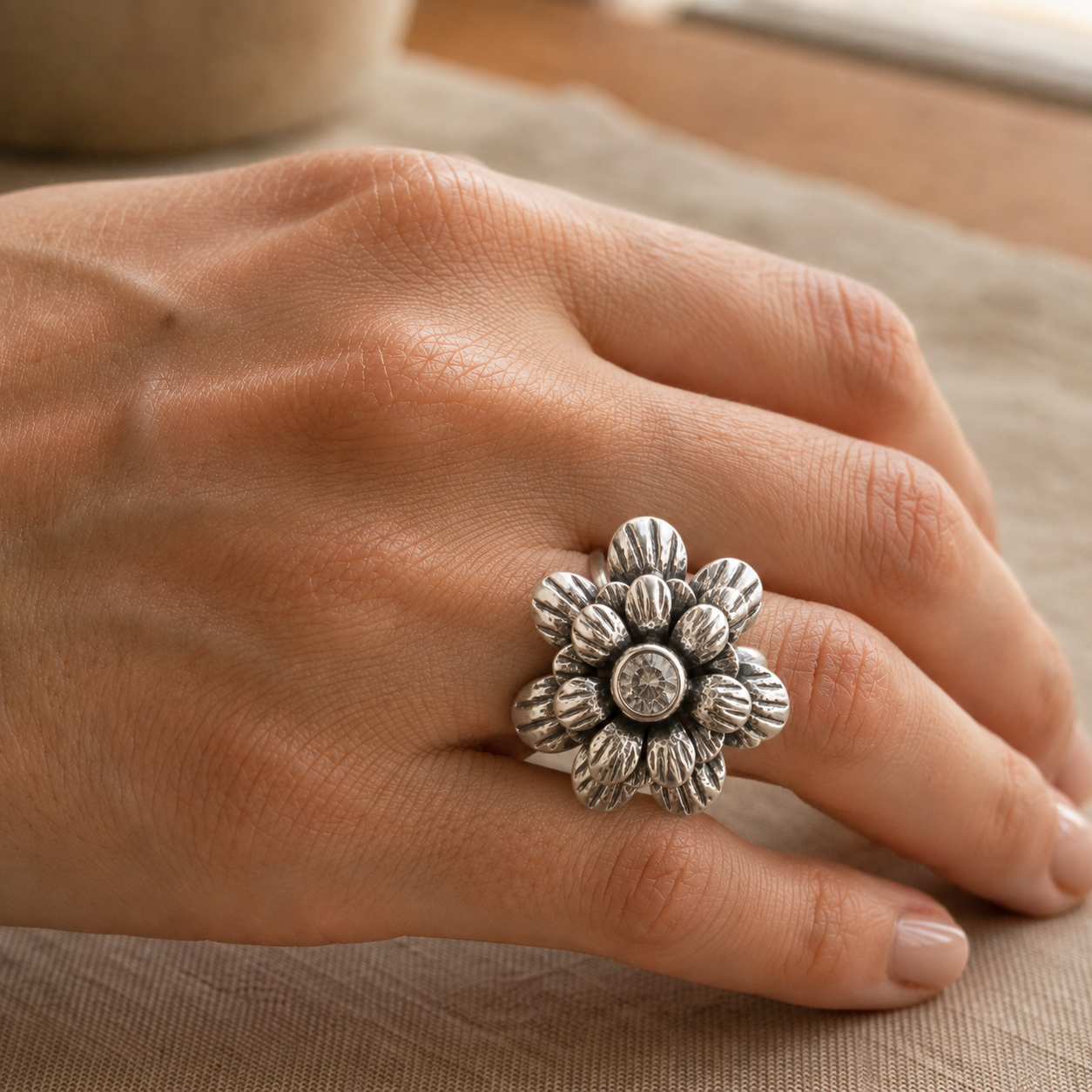 Anillo Flor con Circonia de plata ley .925 puesto en el dedo anular de una mano